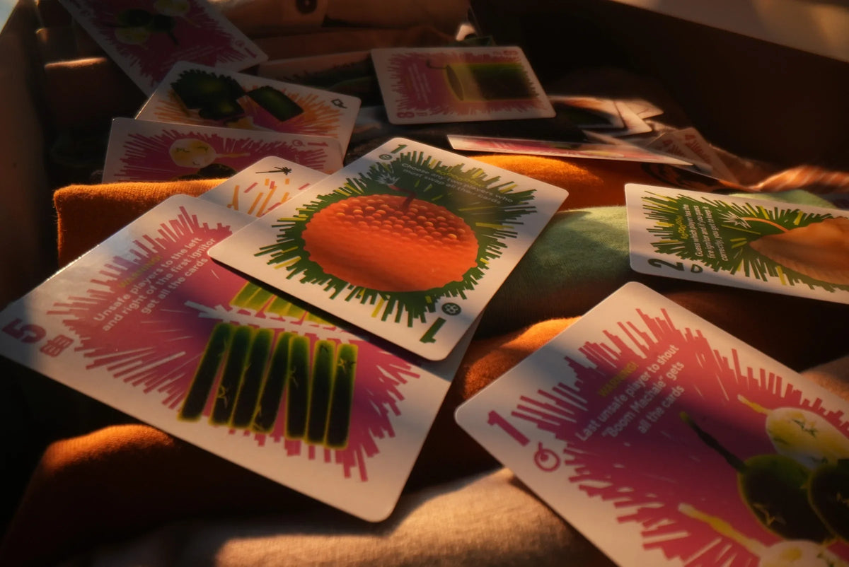 Boom Machale cards spread across fabric in warm afternoon sunlight