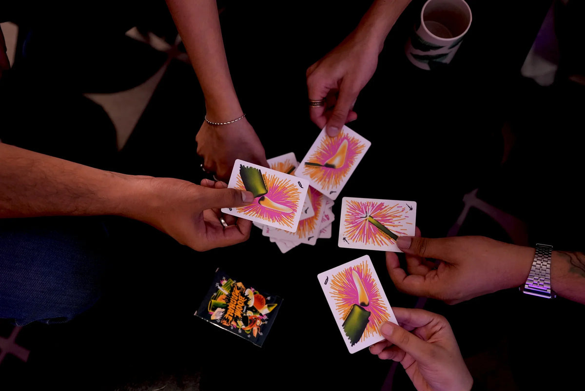 Several players reaching into the centre with Boom Machale cards
