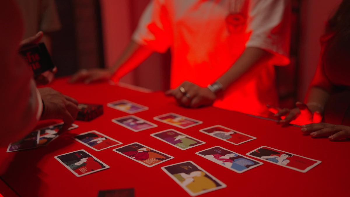 Players dealing Khufia Mafia cards around a table under dramatic red lighting