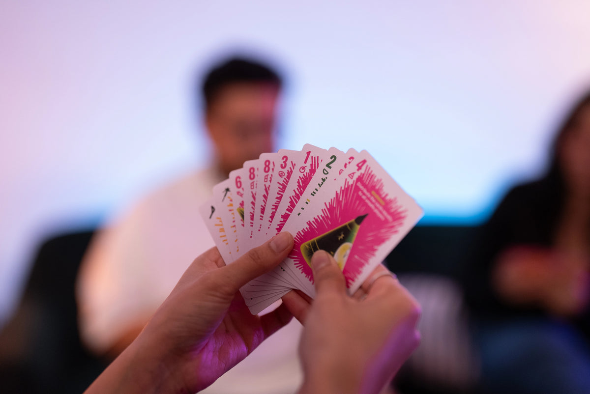 Player holding a fan of Boom Machale cards, deciding on a house rule worthy move