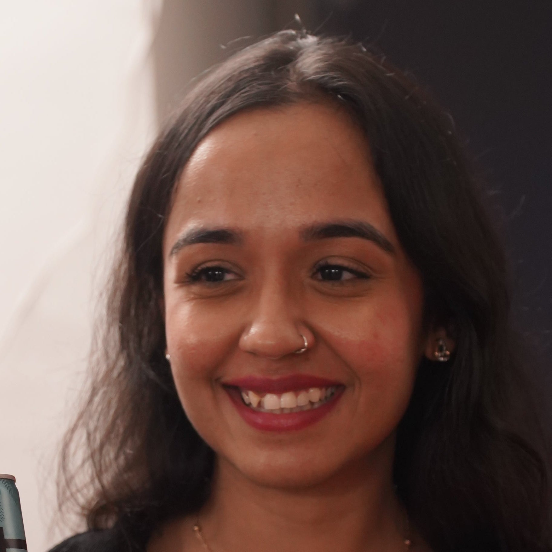 Woman holding a can of soda with a blurred background