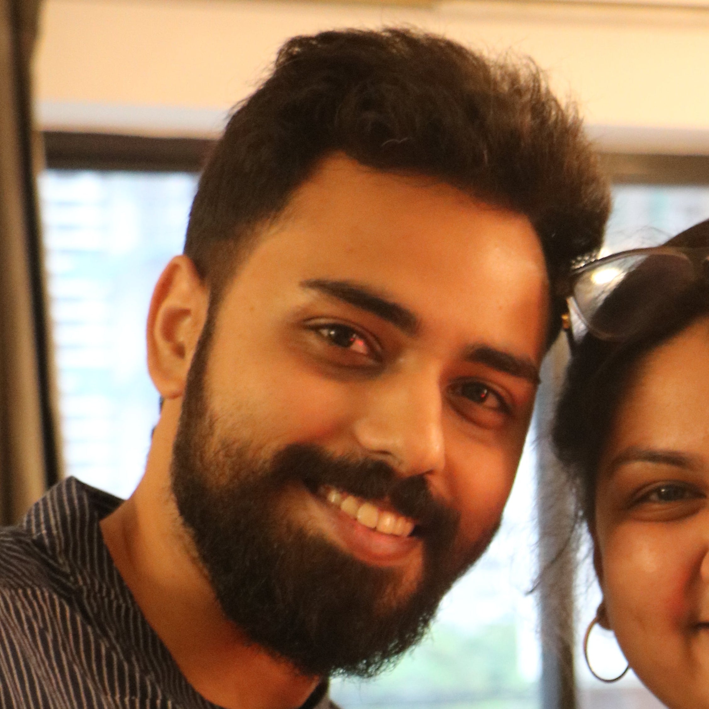 Two people holding up cards with visible branding in an indoor setting.